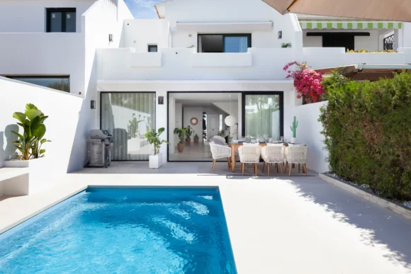 Luz natural iluminando un interior y exterior minimalista con grandes ventanales en una propiedad exclusiva de Marbella